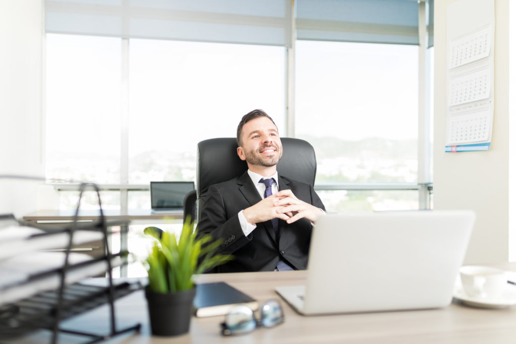 hispanic executive manager thinking about something good while sitting office